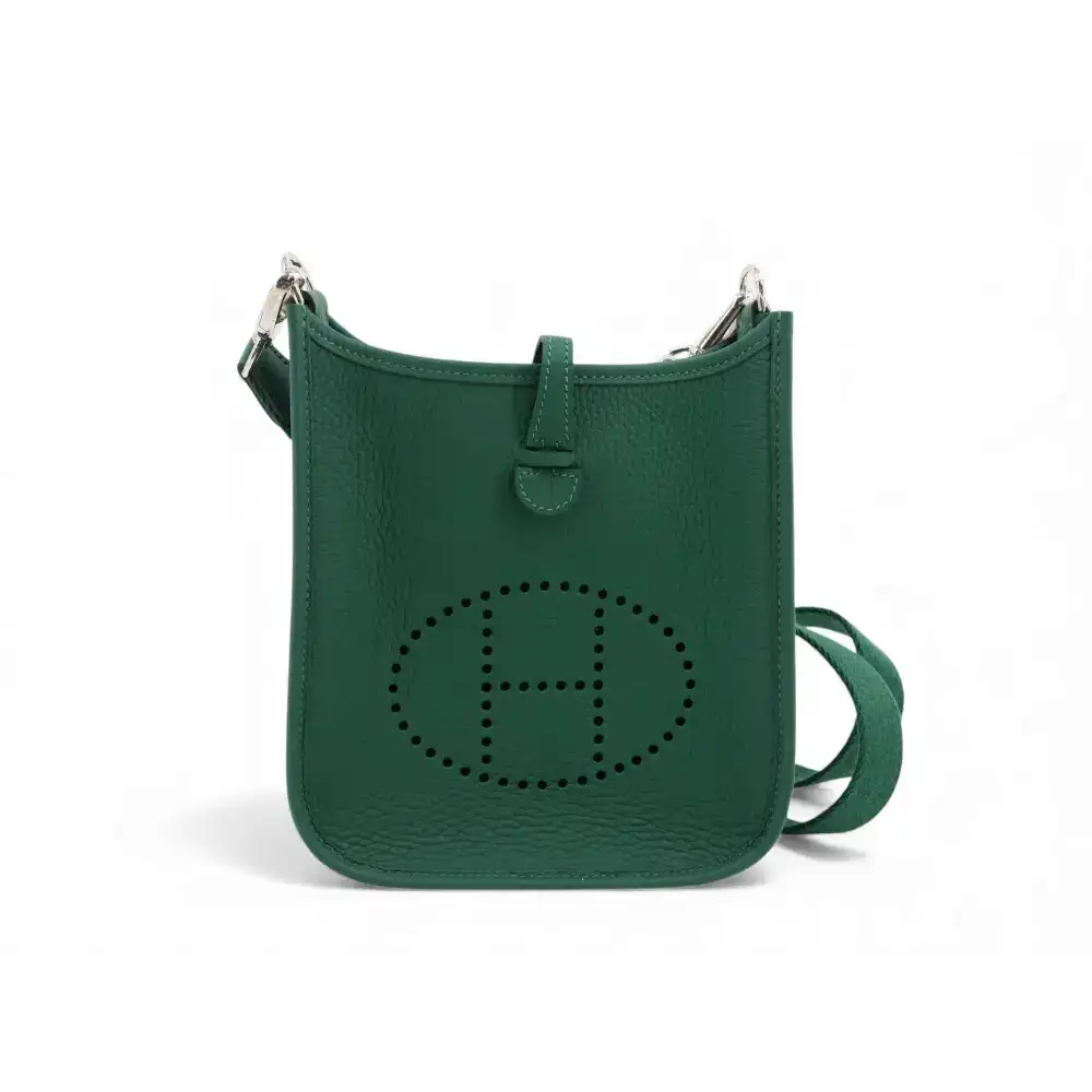 Emerald green leather hermès mini evelyne bag with a perforated ’h’ logo and silver-toned hardware.