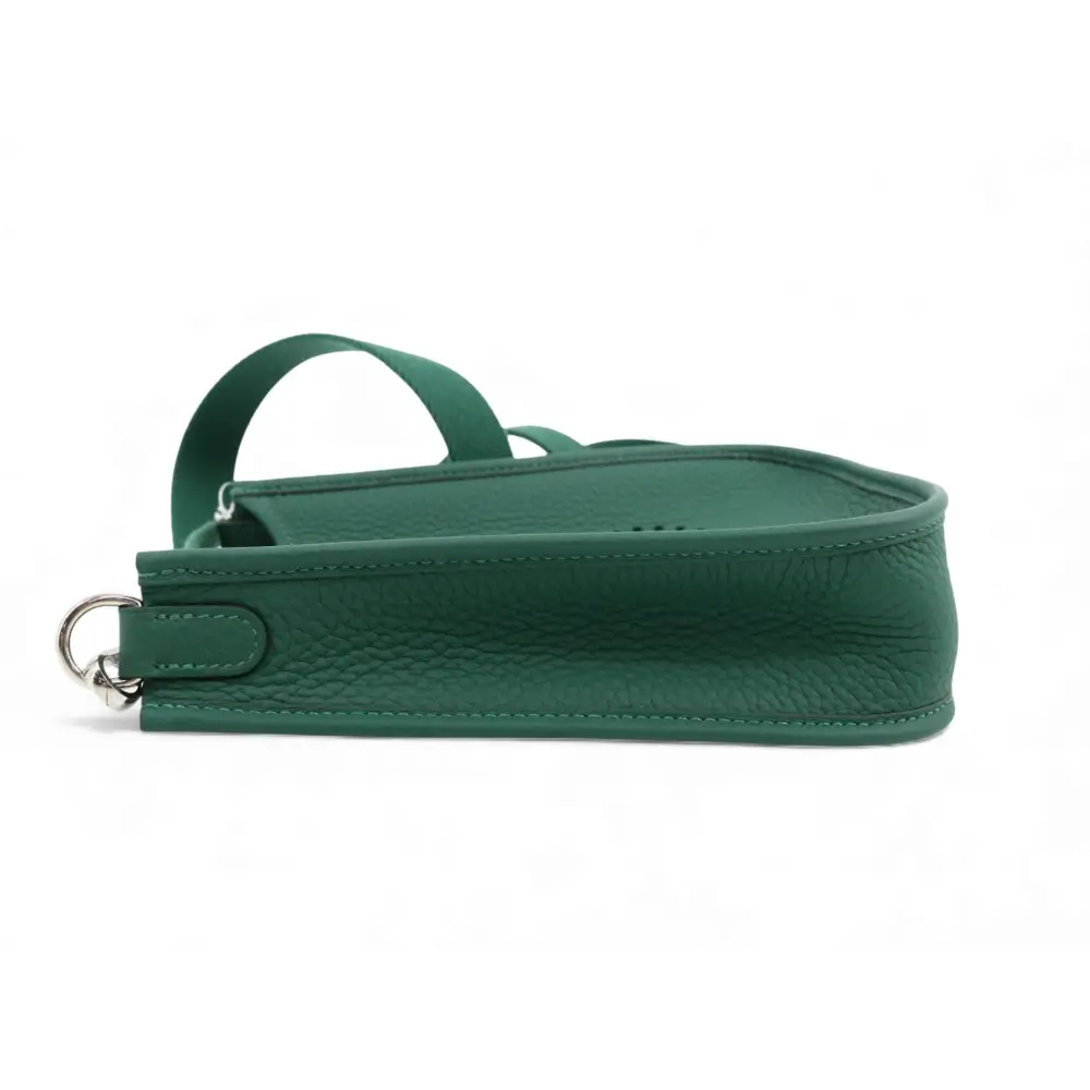 Green leather handbag with a strap on a white background