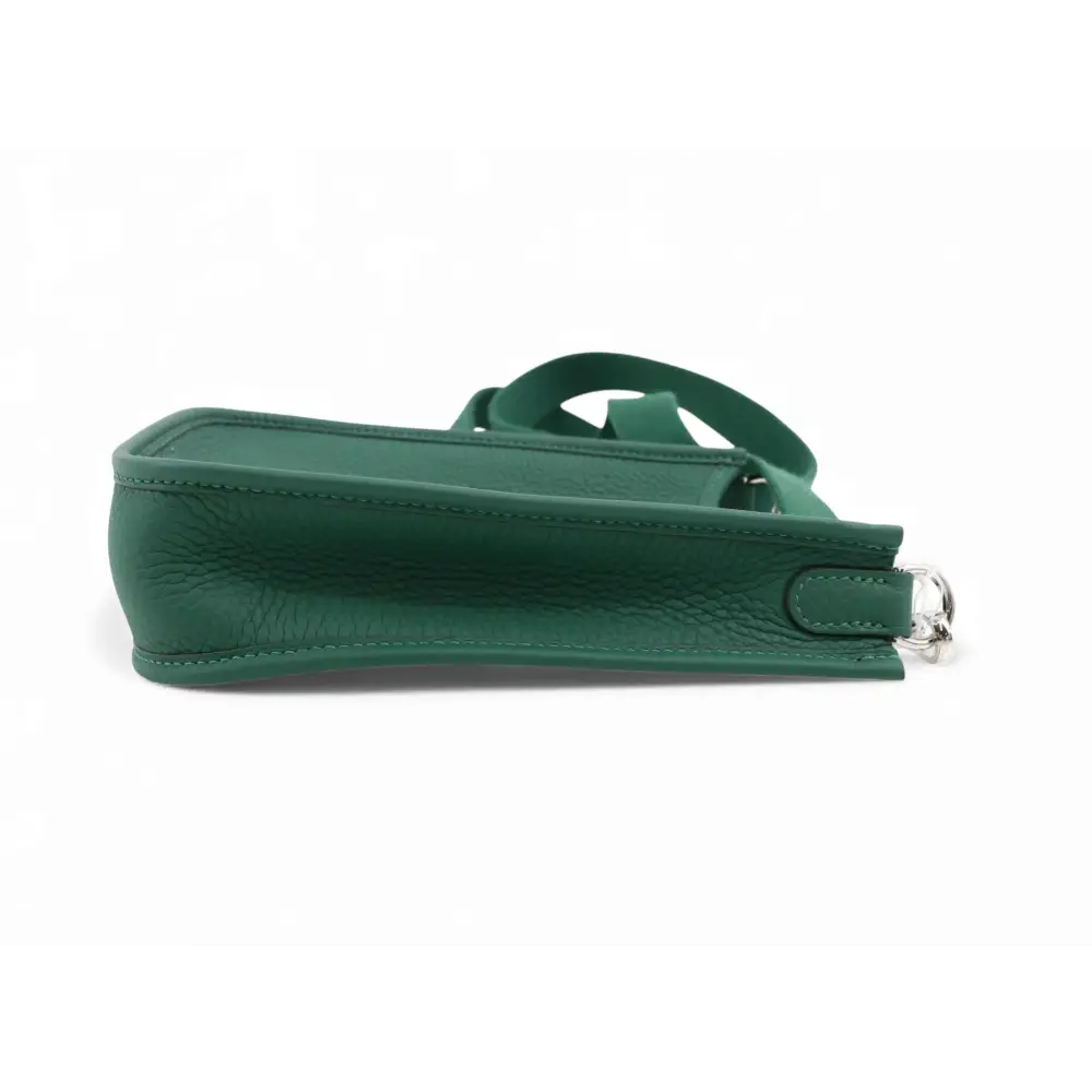 Green handbag with a strap on a white background