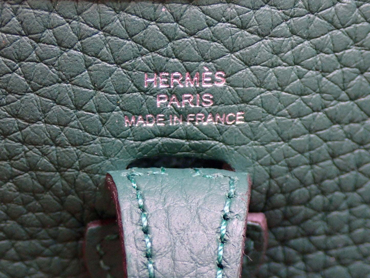 Close-up of a green leather Hermès bag with 'Made in France' text.